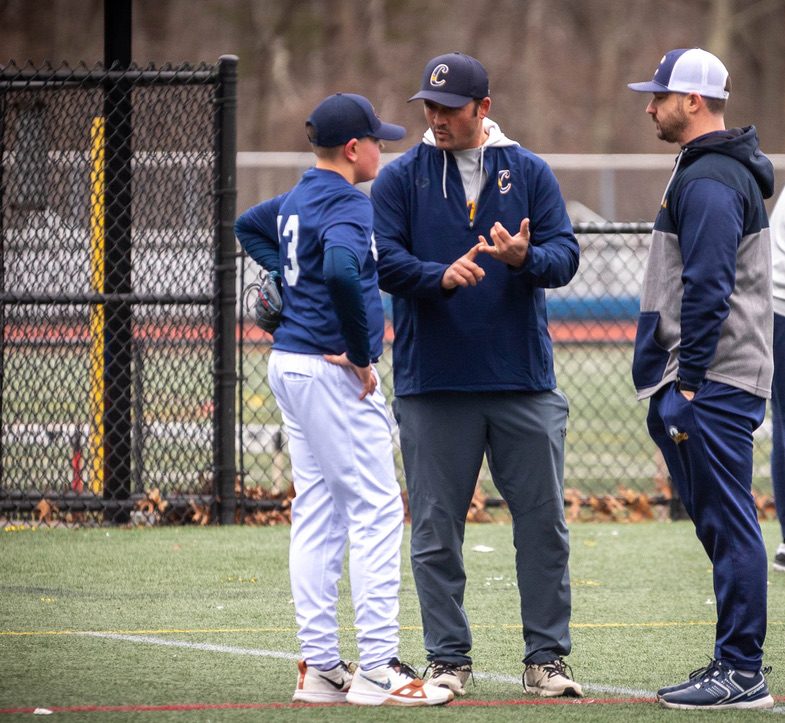 Captains coaches working with a player on the field