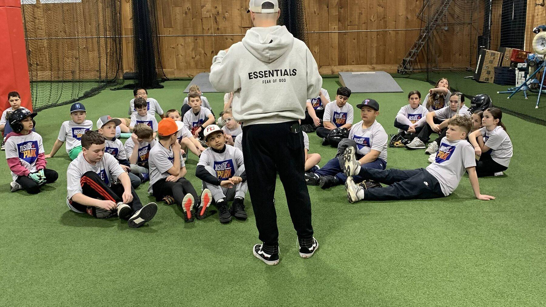 A coach and a clinic group on the turf at Inside the Park